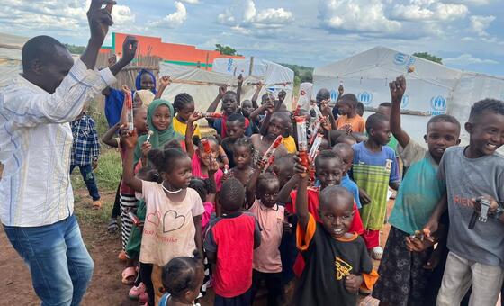 أطفال سودانيون لاجئون في يوغندا يحملون هدايا تلقوها بمناسبة عيد الفطر المبارك.